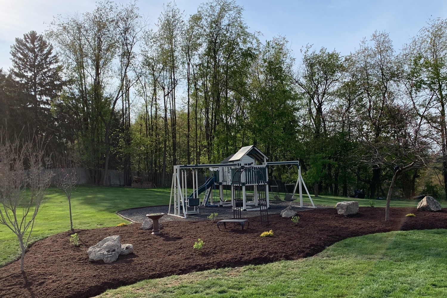 playground landscaping with mulch and rocks and trees